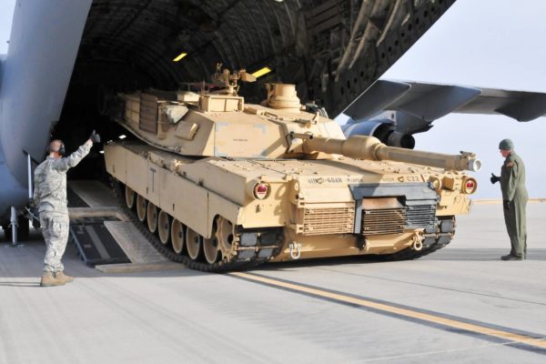 An M1A2 SEP (V2) Abrams tank and a C-17 Globemaster military transport aircraft