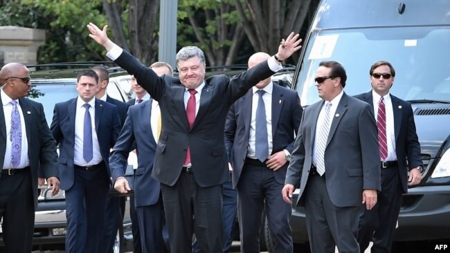 Poroshenko waves happily as he arrives to meet with President Obama